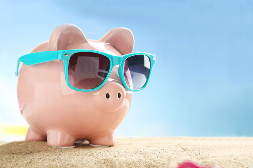 piggy bank in sunglasses on a beach